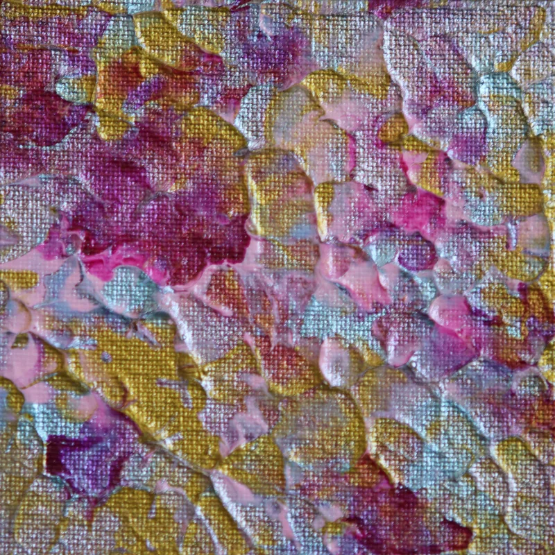 A close-up of abstract artwork in pink and gold.